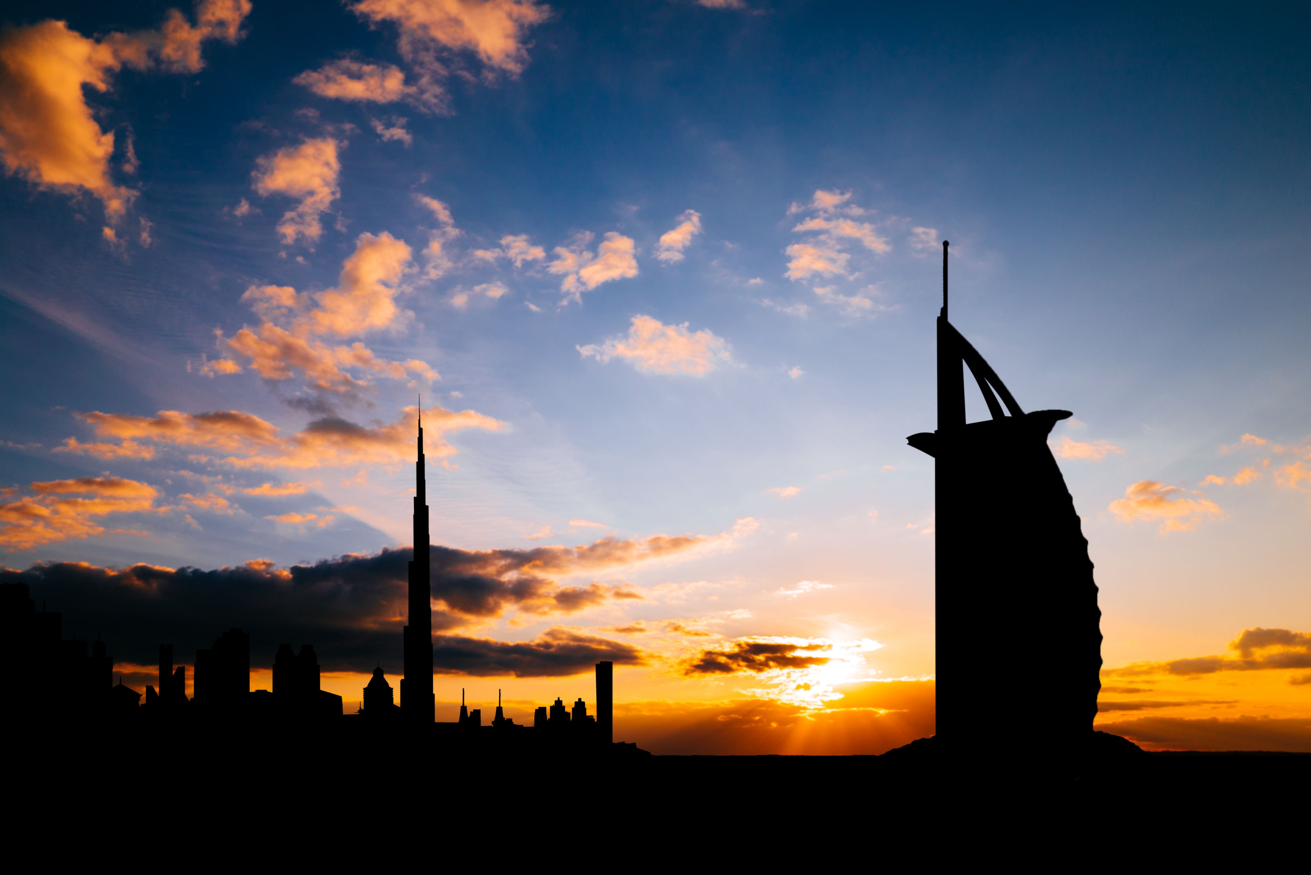 City skyline in silhouette at sunset. Illustrative background, not a listing.